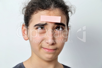 Little girl with memo posts on her forehead,