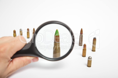Magnifying glass and AK47 bullet close up