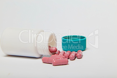 Isolated pills spilling out of pill bottle