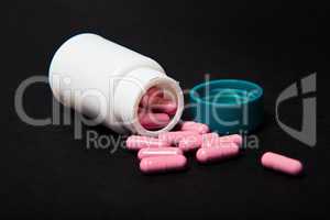 Isolated pills spilling out of pill bottle