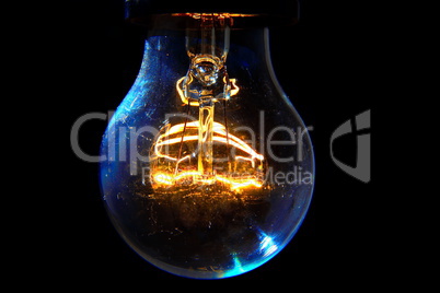 Old light bulb glowing in dark