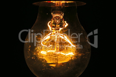 Old light bulb glowing in dark