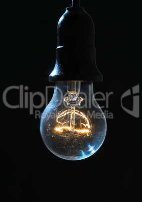 Old light bulb glowing in dark