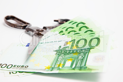 Scissors cuts euro banknote on white background