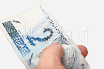 Male hand holding National currency of Brazil.