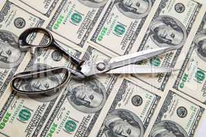 Scissors cuts dollars banknote on white background