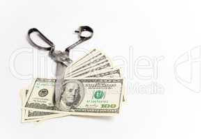 Scissors cuts dollars banknote on white background