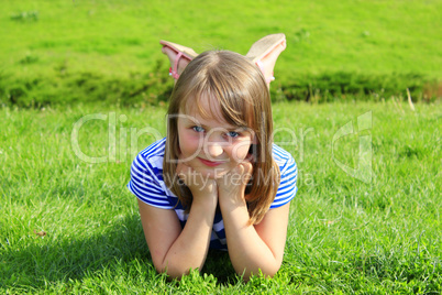 portrait of little girl lying on the grass