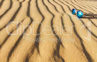 Sunglasses on the sand in the desert.