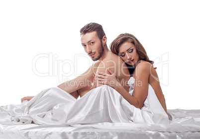 Erotica. Loving couple in bed, isolated on white