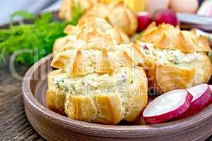 Appetizer of radish and cheese in profiteroles on clay plate wit