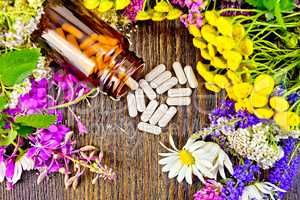 Capsules in brown jar with flowers on board top