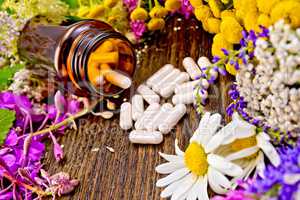 Capsules in open brown jar on board with flowers