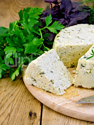 Cheese homemade round with herbs on board