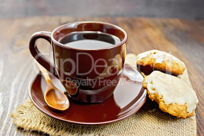 Coffee in brown cup with cookies on board