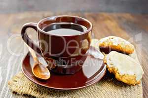 Coffee in brown cup with cookies on board
