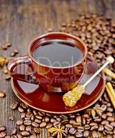 Coffee in brown cup with sugar and star anise on board