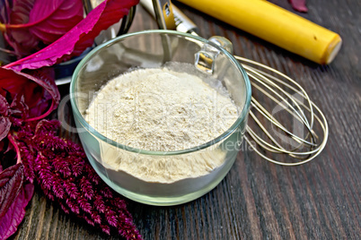 Flour amaranth in cup with rolling pin on board