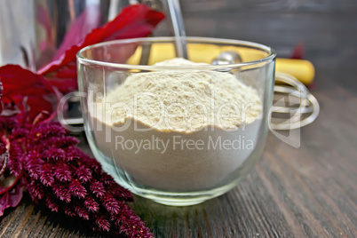 Flour amaranth in cup with sieve on board