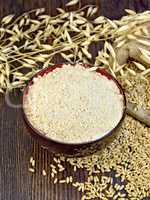 Flour oat in bowl with grain on board