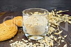 Flour oat in glass with cookies on board
