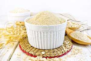 Flour oat in white bowl on board