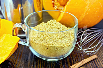 Flour pumpkin in glass cup with sieve and a mixer on board