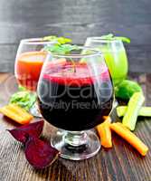 Juice beet and cucumber in wineglass on board