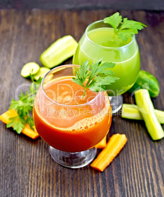 Juice carrot and cucumber in two wineglass on board