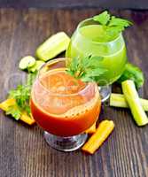 Juice carrot and cucumber in two wineglass on board