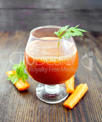 Juice carrot in wineglass on board