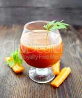 Juice carrot in wineglass on board
