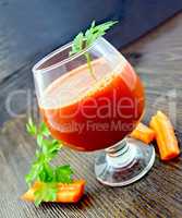 Juice carrot in wineglass on dark board