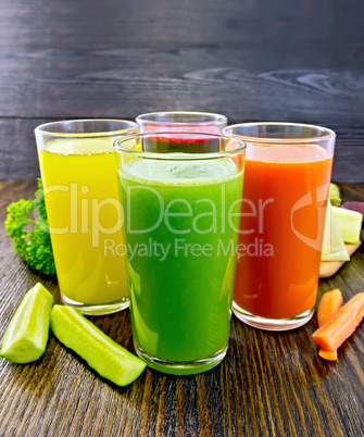 Juice cucumber and vegetable in glassful on dark board