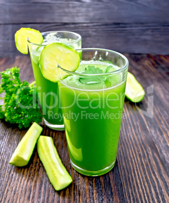 Juice cucumber in two tall glass on dark board