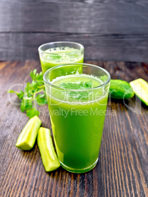 Juice cucumber with parsley in two glass on board