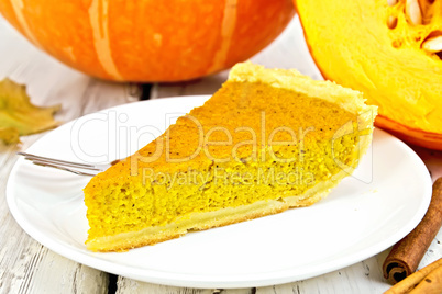Pie pumpkin in white plate on board