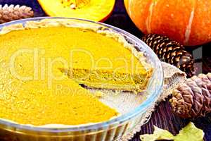Pie pumpkin in glass pan on board