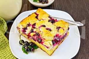 Pie with black currant in plate and fork on board