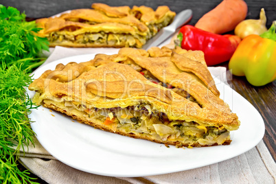 Pie with cabbage and sorrel in plate on dark board
