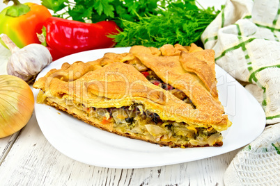 Pie with cabbage and sorrel in plate on light board