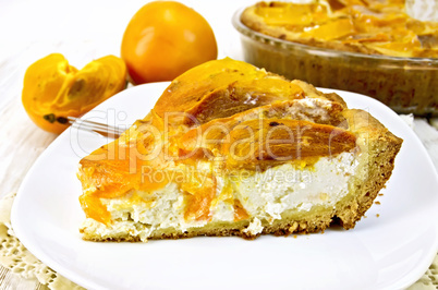 Pie with curd and persimmons in plate on napkin silicone and boa