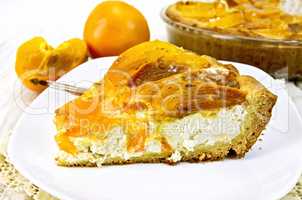 Pie with curd and persimmons in plate on napkin silicone and boa