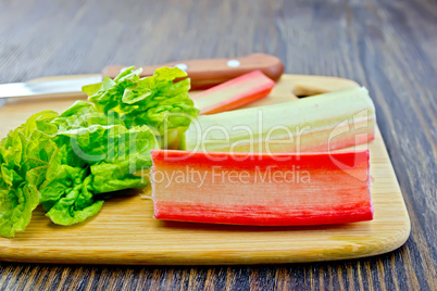 Rhubarb with knife on dark board