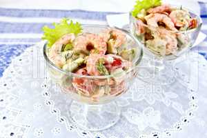 Salad with shrimp and tomatoes in glass on napkin silicone