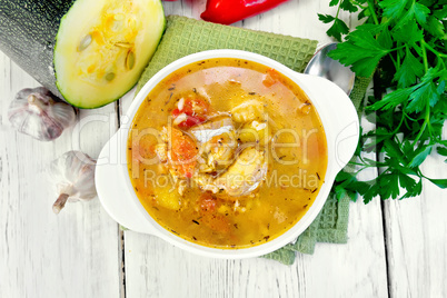 Soup fish with zucchini and peppers on board top