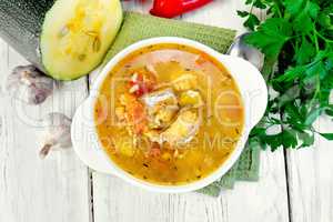 Soup fish with zucchini and peppers on board top