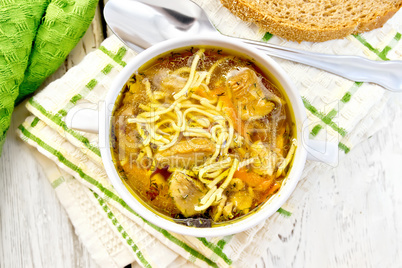 Soup with mushrooms and noodles in bowl on napkin top