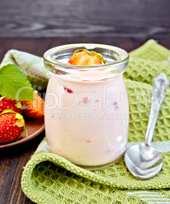 Yogurt with strawberries in jar on napkin
