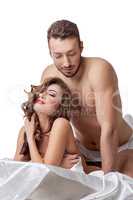 Pretty smiling woman and sexy man posing in bed